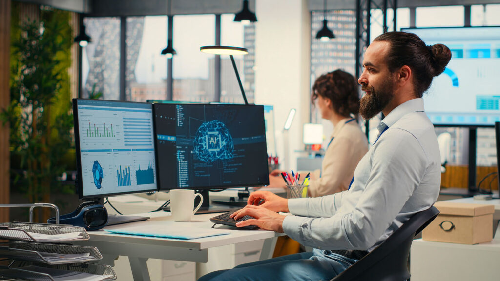 IT professional analyzing AI dashboard on dual monitor workstation